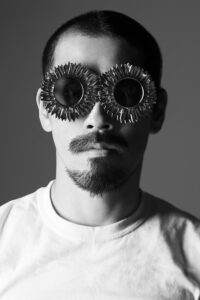 Portrait photographique noir et blanc d'un homme qui porte des lunettes de soleil en forme de tournesol