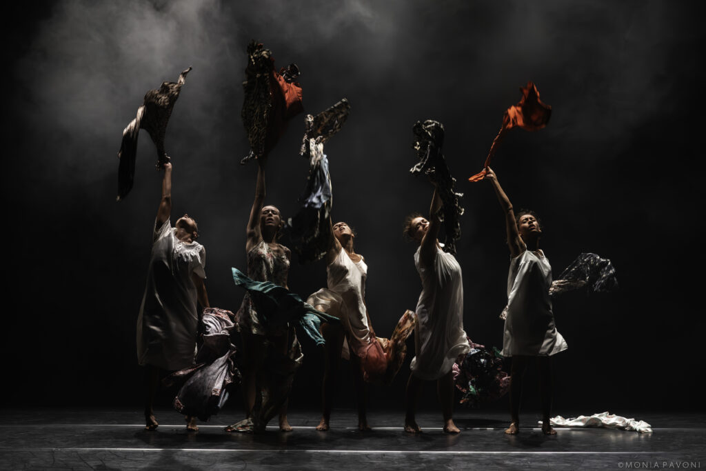 Photographie des cinq interprètes qui lancent des robes en l'air dans le spectacle Maldonne de Leïla Ka