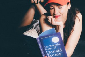 Audrey Vernon en train de lire un livre intitulé "The beautiful Poetry of Donald Trump