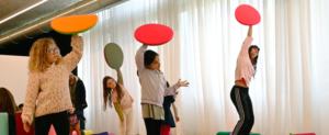 Plusieurs enfants en train de jouer avec des objets en mousse de formes géométriques diverses et colorées.